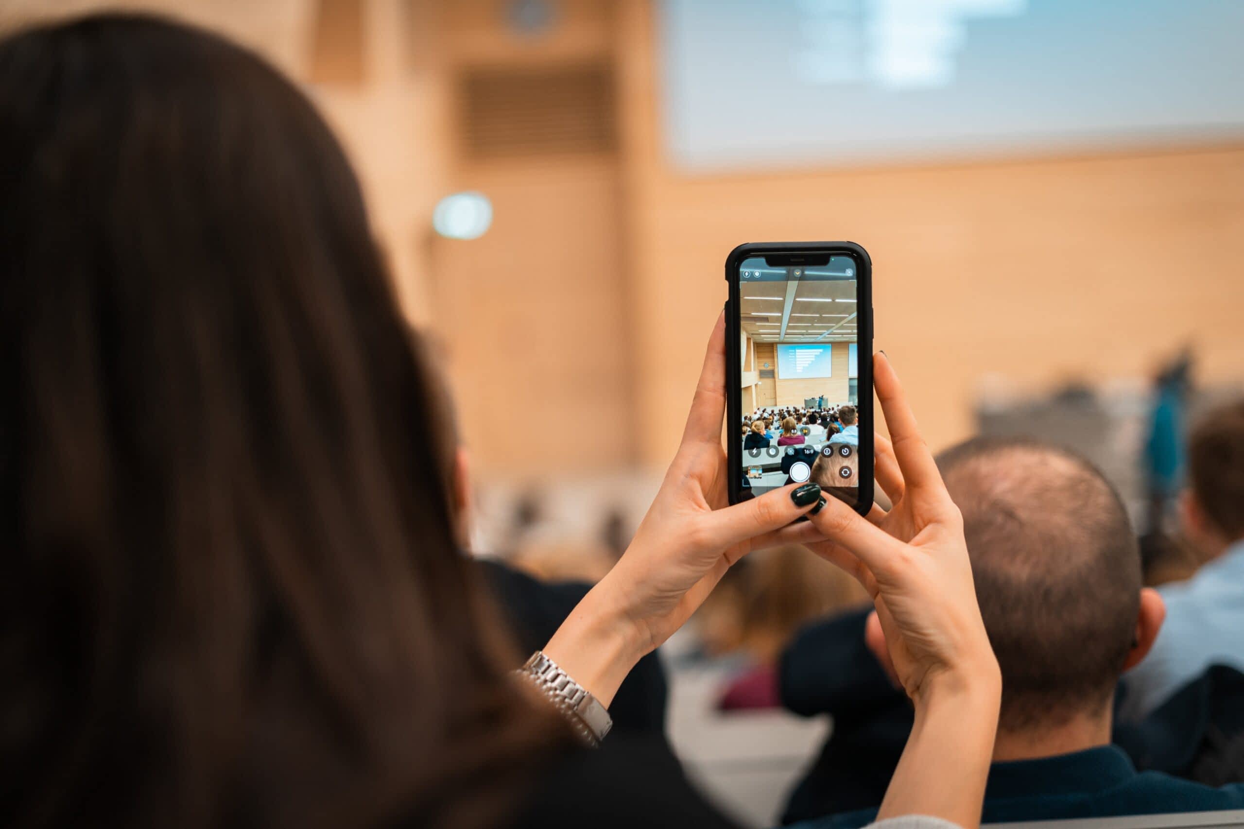 das Event, bzw. der Referent ist hier durch die Smartphone-Kamera einer Teilnehmerin des Events zu sehen